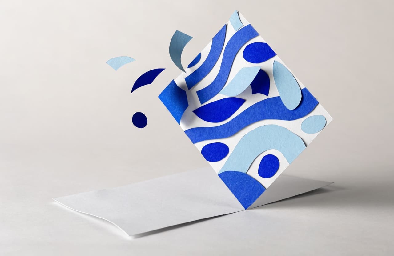 Paper-craft illustration of a colorful designed page sliding off a plain document