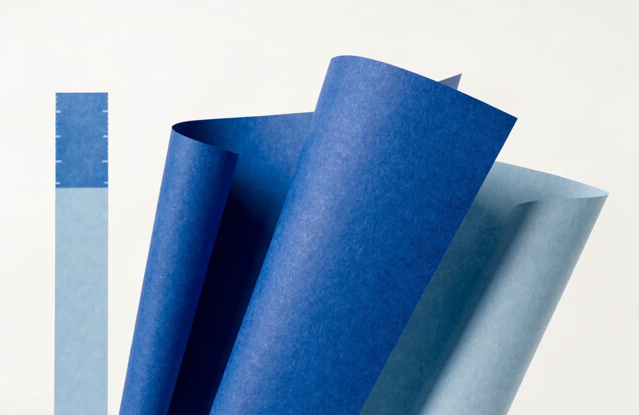 Paper-craft illustration of three paper sheets of different sizes fanned out beside a paper ruler